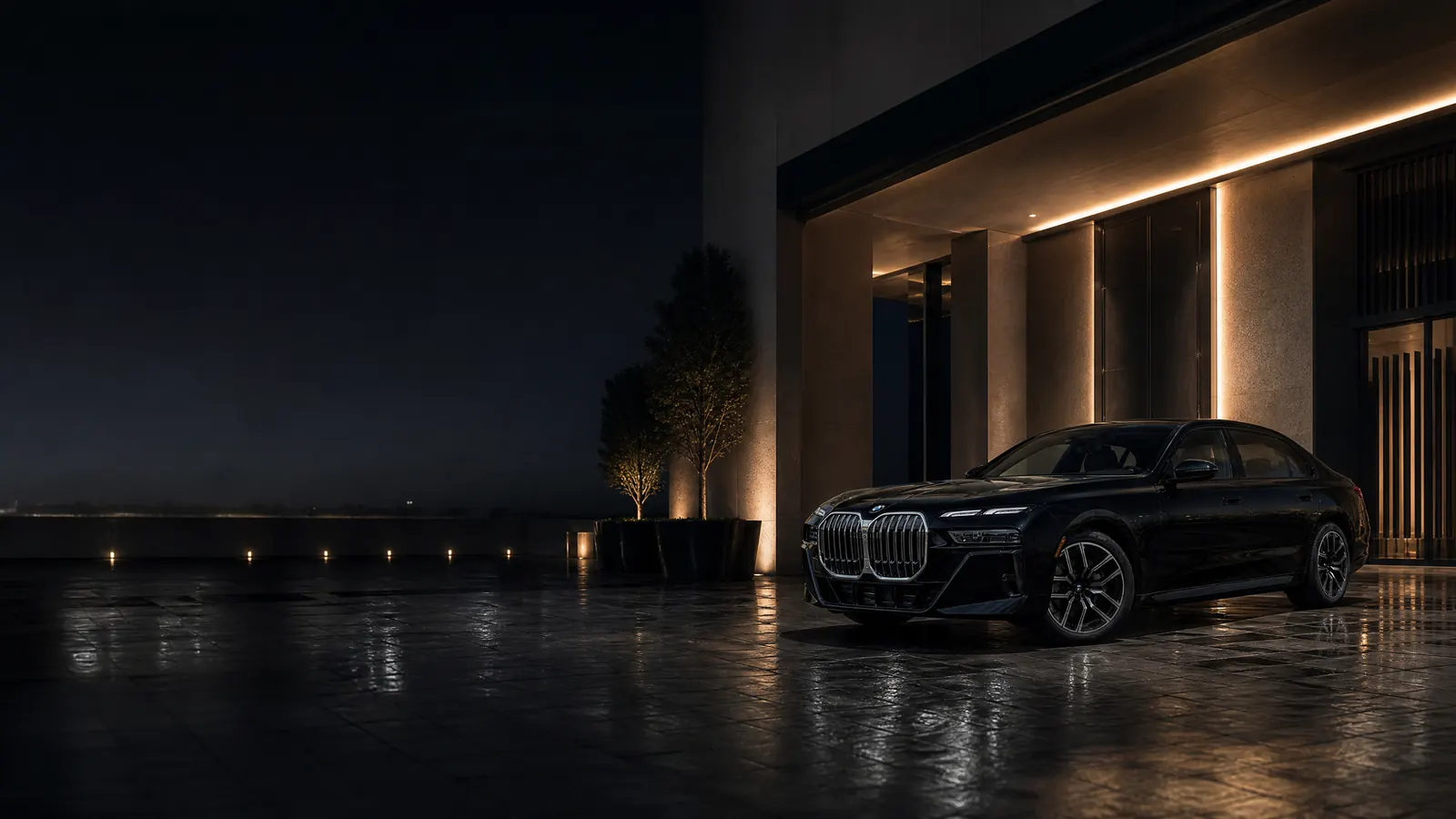 Schwarzer BMW 735i wartet nachts neben zeitgenössischer Architektur in Dubai
